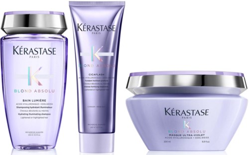 Three purple hair care products from Kérastase Paris: shampoo, treatment, and mask, all labeled Blondes Absolu.