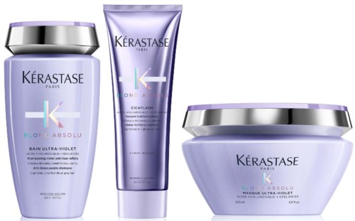 Drei violette Haarpflegeprodukte von Kérastase, einschließlich Shampoo, Conditioner und Maske, in eleganten Behältern.