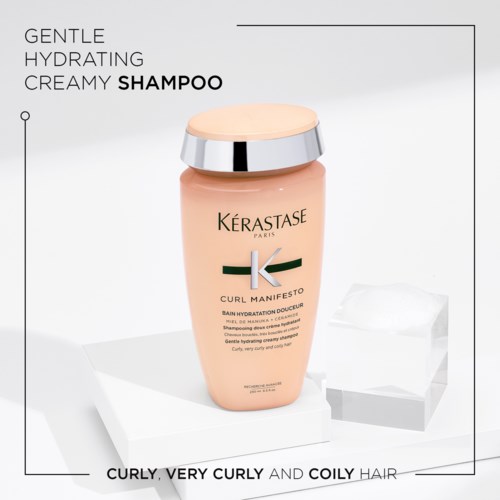Een flesje Kérastase Curl Manifesto voedende shampoo voor krullend en kroeshaar, met tekst die de zachte, hydraterende, crèmetype eigenschappen beschrijft.