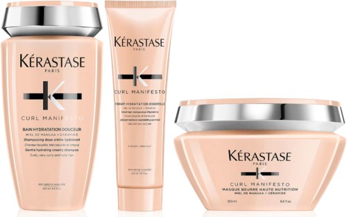 Drie Kérastase Curl Manifesto haarproducten met perzikkleurige verpakking en zilveren accenten.