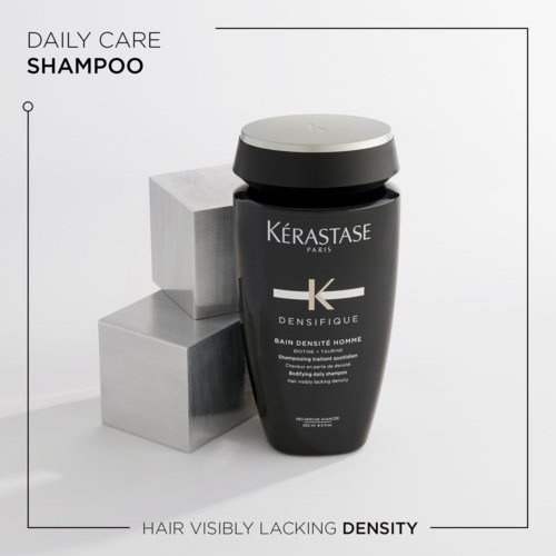 Een zwarte shampoo fles met witte dop, gemerkt Kerastase Paris Densifique, naast drie witte blokken.