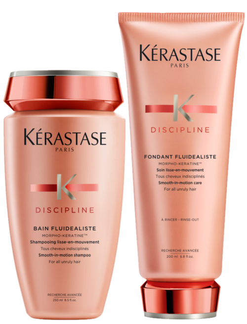 To hårpleieprodukter, en i flaske og en i tube, begge rosa med røde og sølvfargede detaljer, merket 'Kérastase Discipline.'