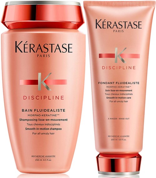 Twee haarverzorgingsproducten van Kérastase Discipline, shampoo en conditioner, in roze verpakkingen.