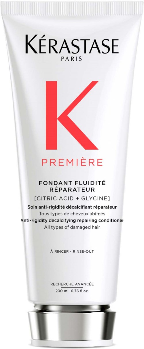 A white tube of Kérastase hair product with red and black text, mentioning it is for damaged hair repair.