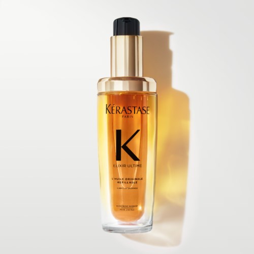 A bottle of hair oil with a gold and black cap, labeled 'Kérastase Elixir Ultime' on a plain background.
