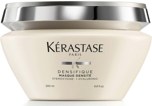 Een witte pot met zilveren deksel, gemarkeerd Kérastase Paris, voor haarmasker met hyaluronzuur en stemoxydine.