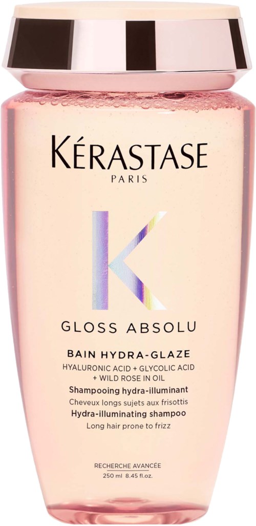 A pink bottle of Kérastase Gloss Absolu shampoo with a shiny silver cap.