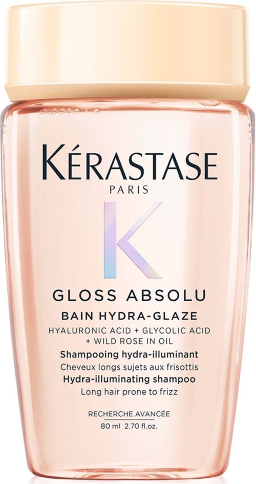 En rosa flaska av Kérastase Gloss Absolu schampo med en beige lock, innehåller hårvårdsingredienser.