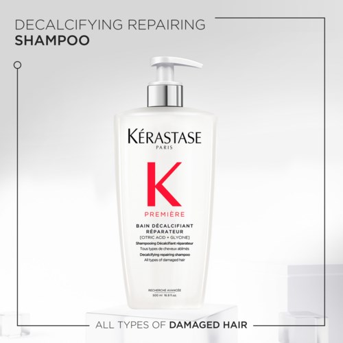 En hvit sjampo-flaske med pumpe, merket 'KERASTASE,' for skadet hår med aktive ingredienser. Det er Premier Decalcifying Repairing Shampoo.