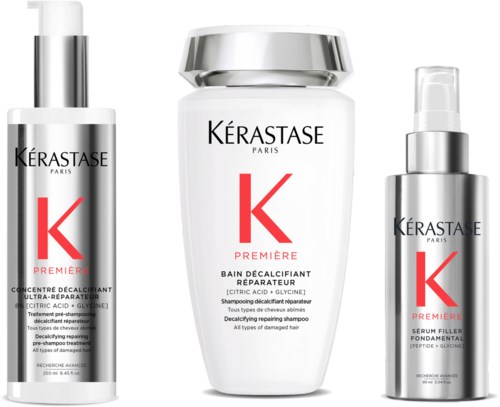 Drie witte huidverzorgingsflessen met zilveren doppen, met Kérastase logo en rode 'K' in het midden.