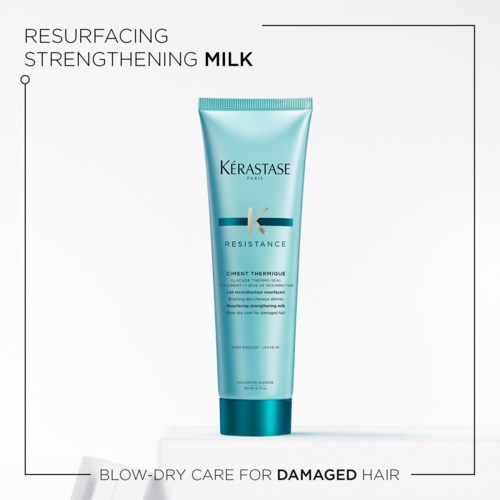 Een blauwe tube Kérastase Resistance haarbehandeling voor beschadigd haar, gelabeld als herstructurering en versterkende melk.