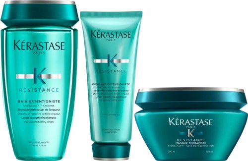 Drie haarverzorgingsproducten in tealhouders, inclusief shampoo, conditioner en masker, met merknaam Kérastase Paris.
