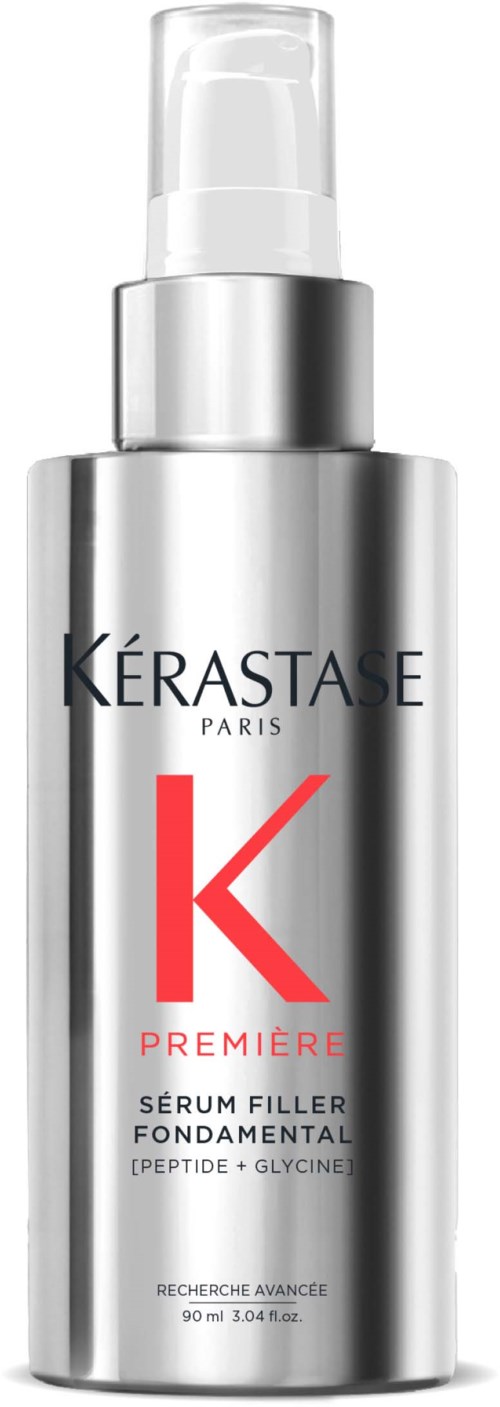 Een zilverkleurige fles met pomp, gemarkeerd Kérastase Paris, bevat een serum voor huid of haar. Rode K en tekst.