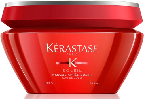 Een rode pot van Kérastase Soleil haarmasker met zilveren deksel, gemarkeerd 'Masque Après-Soleil Eau de Coco' voor na-zon verzorging.