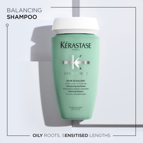 Eine grüne Flasche Kérastase Ausgleichsshampoo für fettige Wurzeln und empfindliche Kopfhaut mit Text und Logo.