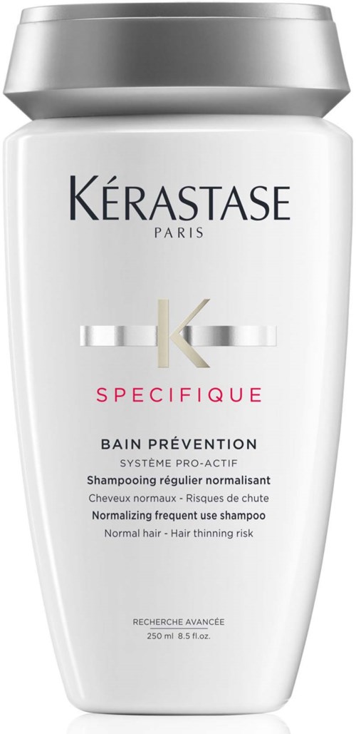 Een witte shampoefles met een zilverkleurige dop, voor haaruitvalpreventie, van Kérastase Paris.