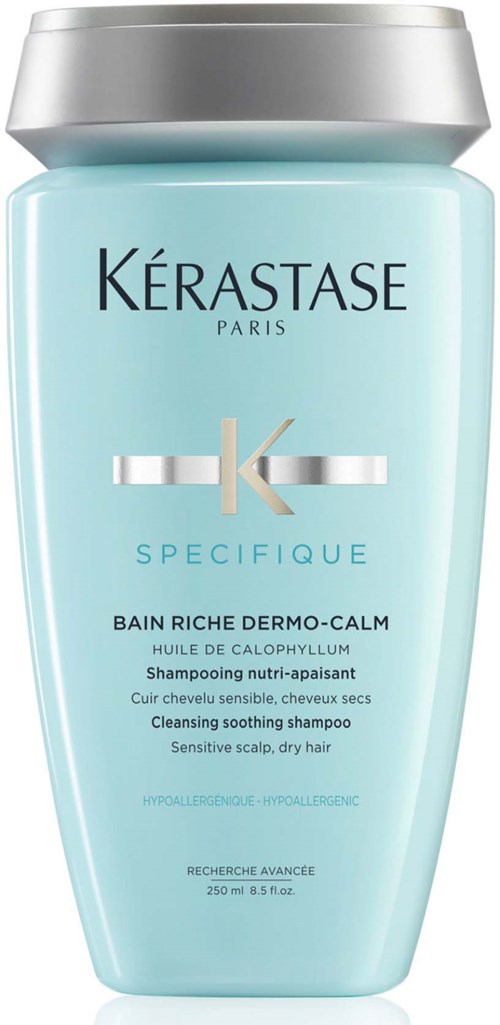 Een lichtblauwe fles Kerastase-shampoo met zilveren dop, voor een gevoelige hoofdhuid en droog haar.