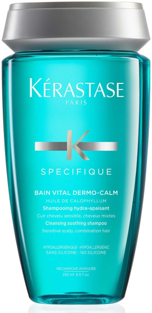 Een turquoise flesje Kérastase-shampoo met zilverkleurige dop, geschikt voor gevoelige hoofdhuid en milde reiniging.