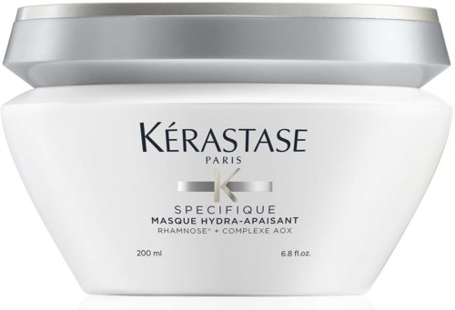 Een witte pot met zilveren deksel bevat haarmasker van Kerastase Paris, voor kalmerende en hydraterende haarverzorging.