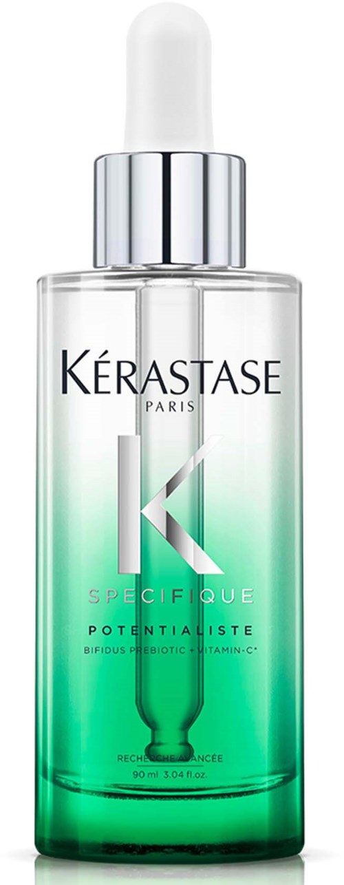 Een heldere glazen fles met pipetdop, bevat een groen getinte vloeistof, gemarkeerd 'Kérastase Paris Specific.'
