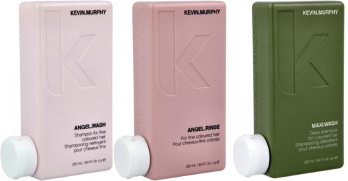 Three bottles of Kevin Murphy hair wash products in white, pink, and green, with large 'K' logos and white caps.