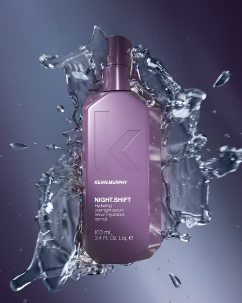 Een paarse fles met 'Kevin Murphy Night Shift' erop, omgeven door spatwater.