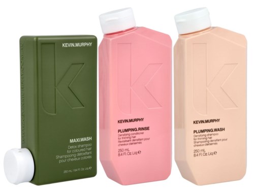 Tre schampoflaskor i grönt, rosa och persika med vita lock, märkta Kevin Murphy och olika produktnamn.