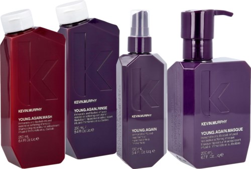 Vier dunkelviolette oder rote Flaschen mit Kevin Murphy Haarprodukten, gekennzeichnet Young.Again, mit Pumpe oder Verschluss.