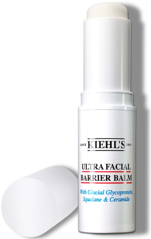 A white tube of Kiehl's Ultra Facial Barrier Balm with white cap and label details. A rounded white sponge is nearby.