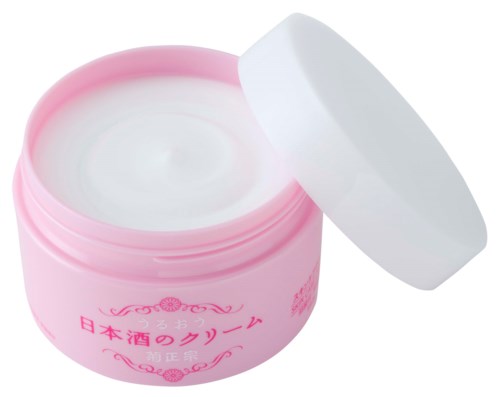 Ein rosa Behälter mit japanischem Text und weißem Deckel, geöffnet, um weiße Creme zu zeigen.