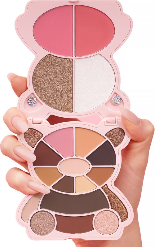 A makeup palette with various eyeshadow shades and blush, held in a hand with nails. The palette has a mirror.