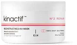 Een witte pot met zwarte en rode tekst, gelabeld 'kinactif' en 'N°2 REPAIR'. Het zegt 'RECONSTRUCTING 2-IN-1 MASK' en informatie voor haar en hoofdhuid.