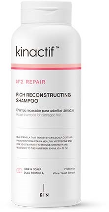 Een witte shampoefles met label 'Kinactif No. 2 Repair' voor beschadigd haar, met roze en zwarte tekst.