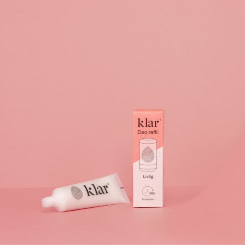 Een deodorant refil tube en doos staan tegen een roze achtergrond. De doos heeft de naam 'klar' en 'Deo refill'.