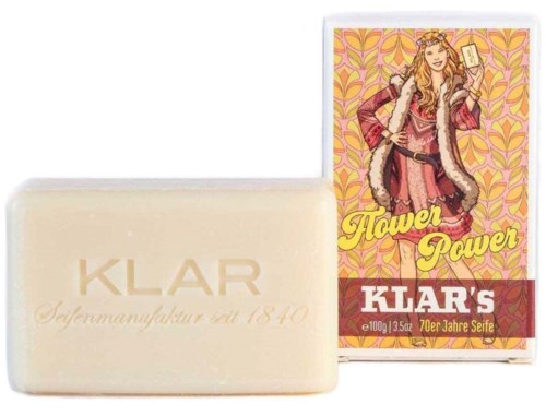 A bar of soap and a colorful box with a girl holding a phone and the text "Flower Power" and "Klar's".