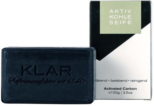 Black soap bar with blue embossed text and soap box with green, black, and white design and text.