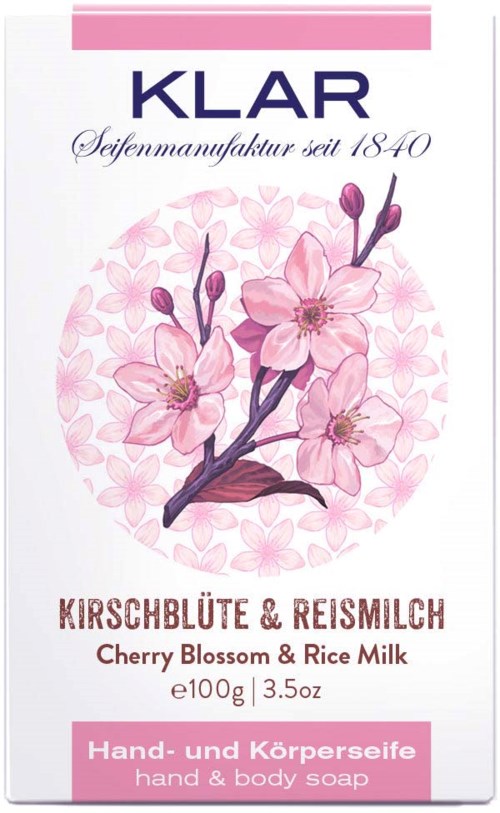 A soap package with cherry blossoms, pink and brown colors, and text in multiple languages.