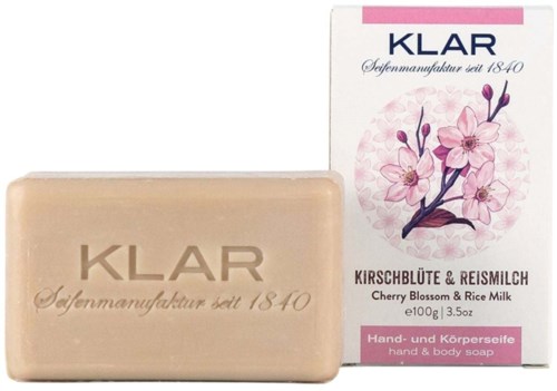 A bar of soap with "KLAR" on it, and a box showing cherry blossoms and rice milk scent.