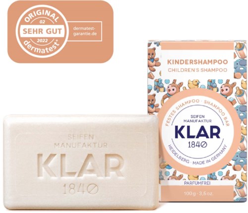 A children's shampoo box decorated with bear faces and a soap bar with the KLAR logo and manufacturing details.