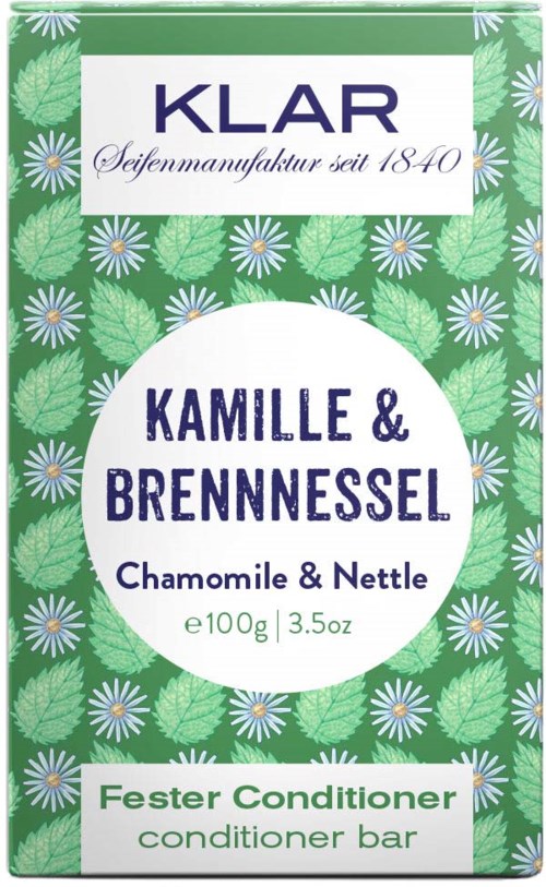 A green box with flowers and leaves, featuring text about chamomile and nettle conditioner for hair care.