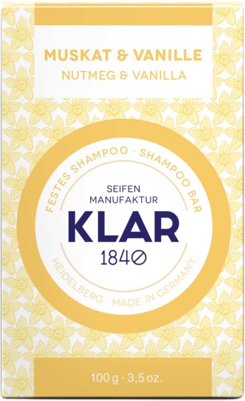Text on packaging about musk and vanilla shampoo in German and English. Gold and white design with floral pattern.
