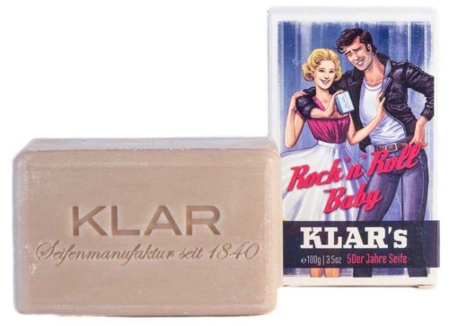 A soap bar labeled 'KLAR' next to a box with 50s rock and roll themed illustration.