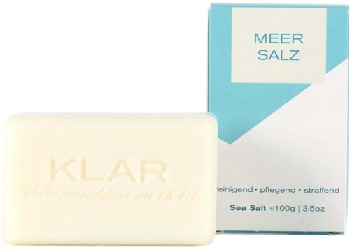 A bar of soap labeled "KLAR" next to a box with "MEER SALZ" written on it, indicating sea salt soap.
