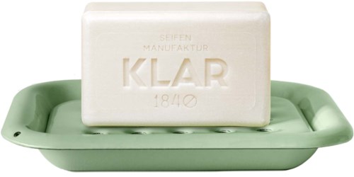 A bar of white soap with green dish, showing embossed text, on a matching soap dish.