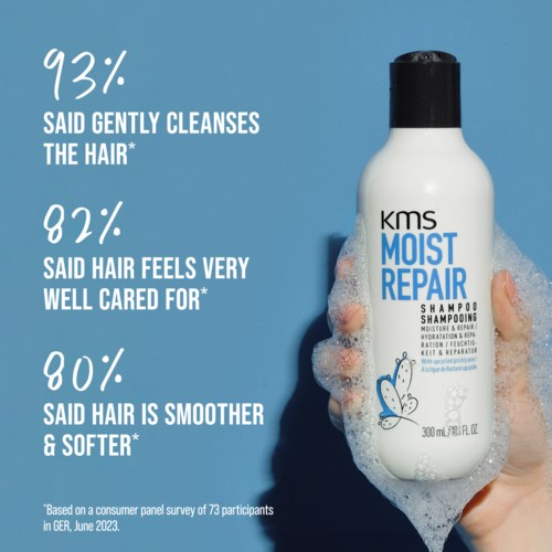 Een hand houdt een shampoo fles met schuim, blauwe achtergrond en tekst over haarvoordelen, zoals reinigen en verzachten.