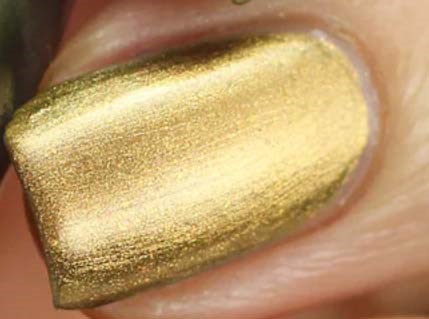 Nahaufnahme eines Fingernagels mit glänzendem Goldnagellack.