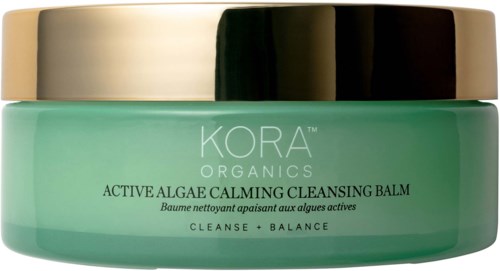 Ein grüner Behälter mit silbernem Deckel, bezeichnet als KORA Organics aktive Algen beruhigendes Reinigungsbalsam.