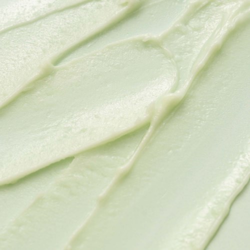 Nahaufnahme von glatter, hellgrüner Creme oder Gel mit Streifen und Textur.