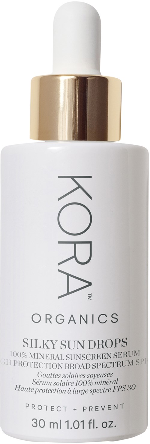 Eine weiße Flasche mit goldener Kappe, beschriftet KORA Organics Silky Sun Drops mineralischer Sonnenschutzserum, 30 ml.