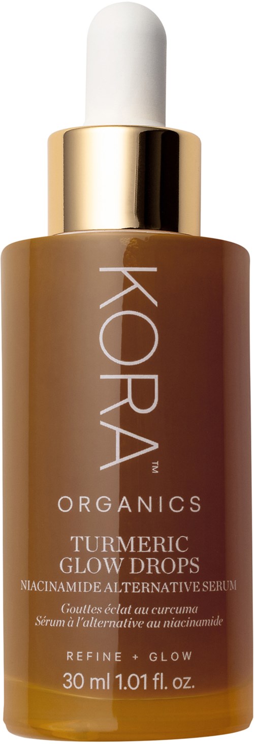 Fles met KORA Organics turmeric glow drops serum met witte pipetdop, gouden rand en bruine fles. Belangrijk product zichtbaar.